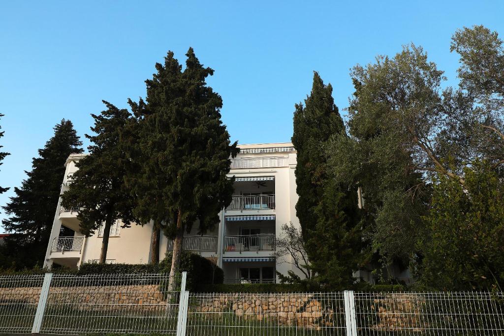 un edificio blanco con árboles delante de él en Apartments Amabilis, en Selce
