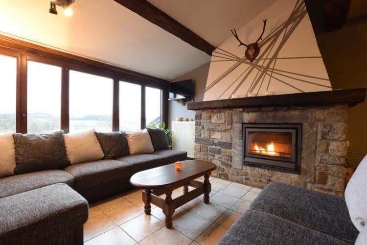 a living room with a couch and a fireplace at La Belle Vue in Roy