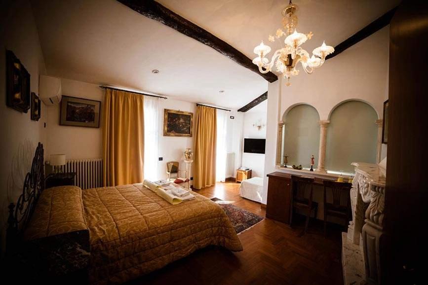 Camere Nicolina في فيرنازا: غرفة نوم بسرير ومرآة كبيرة