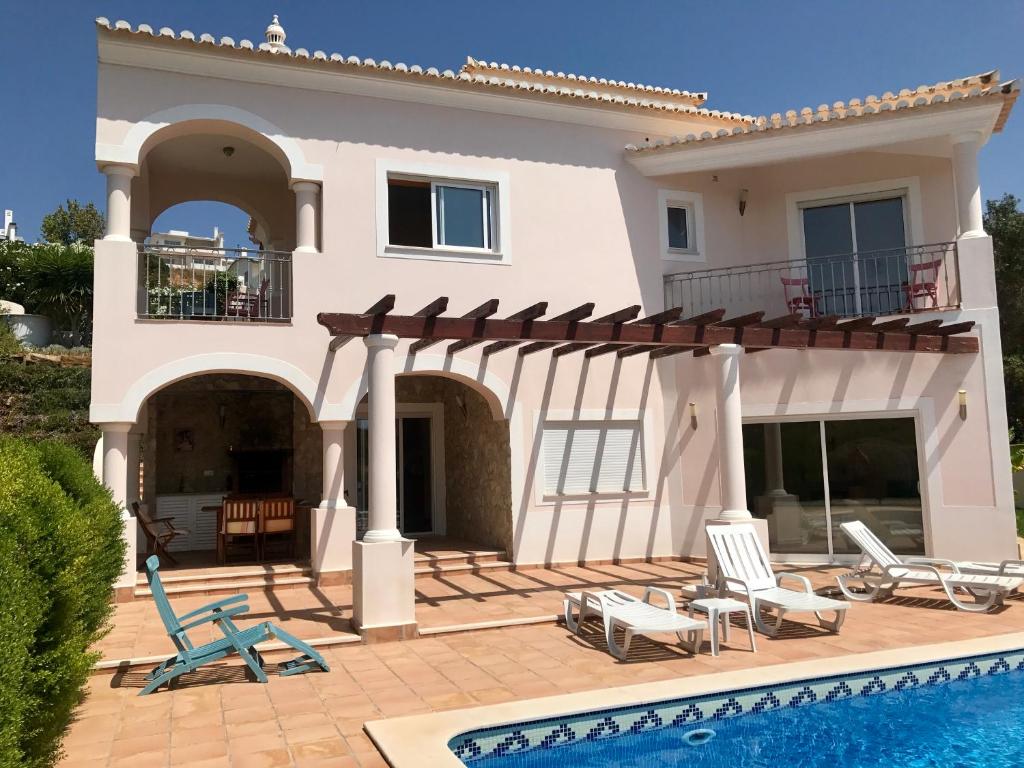 a villa with a swimming pool and a house at Lovely Burgau villa just 3 mins walk from beach in Budens