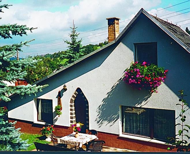 Una pequeña casa con una mesa y flores. en Ferienhaus Gläser en Bockau