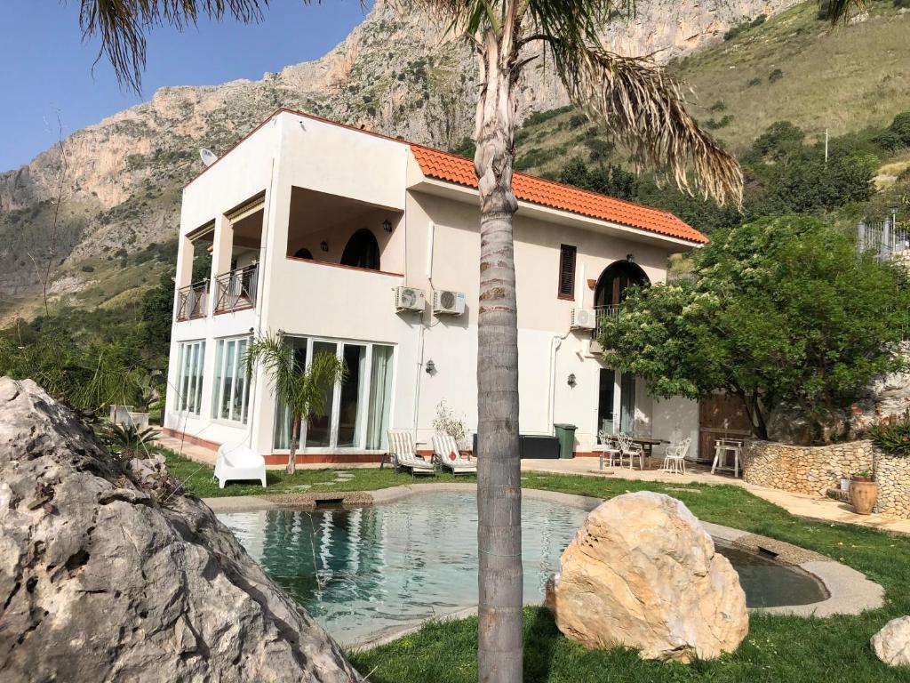 a house with a palm tree in front of it at Villa Bologna in Capaci