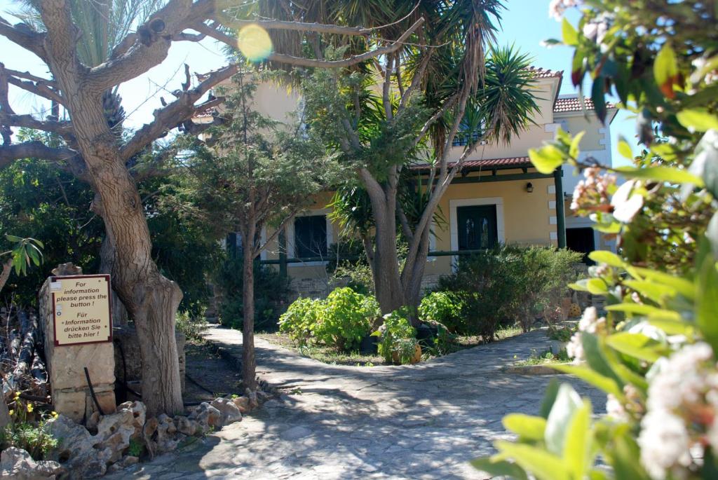 una casa con árboles y un cartel delante de ella en Eleni Apts, en Kamilari