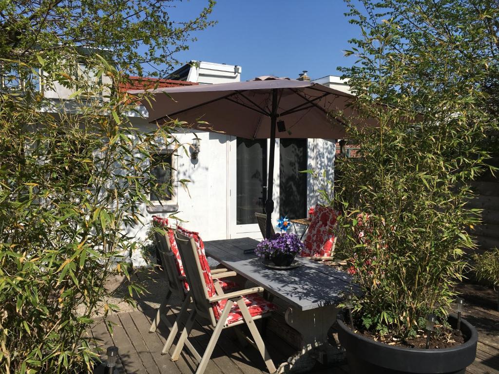 - une table et des chaises sous un parasol dans le jardin dans l'établissement Beachstudio De Schelp, à Zandvoort