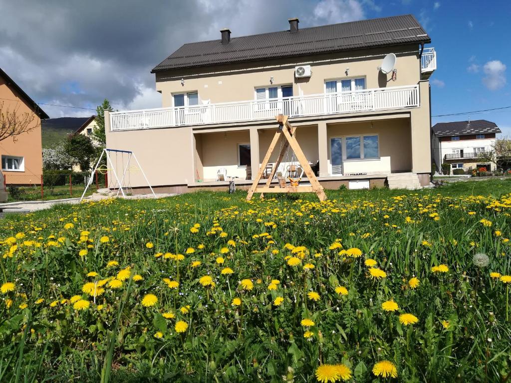 ein Blumenfeld vor einem Haus in der Unterkunft Apartment and Rooms Aračić in Korenica