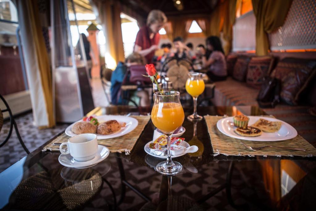 a table with plates of food and glasses of orange juice at Riad Challa Hotel & Spa in Marrakesh