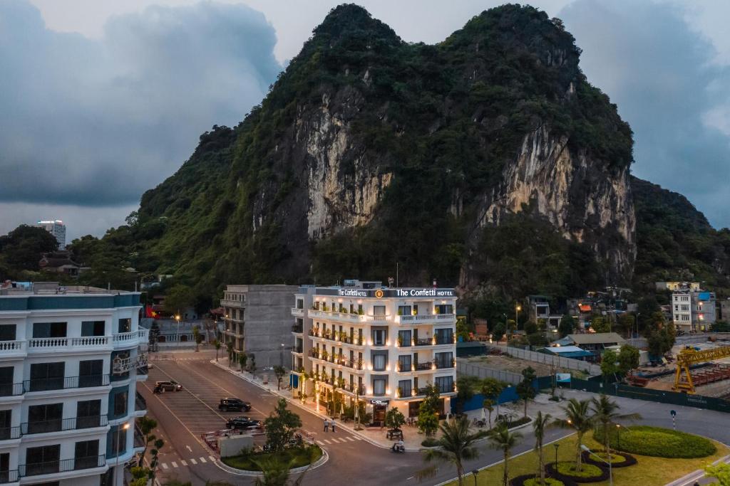 uma montanha no fundo de uma cidade com edifícios em The Confetti hotel em Ha Long