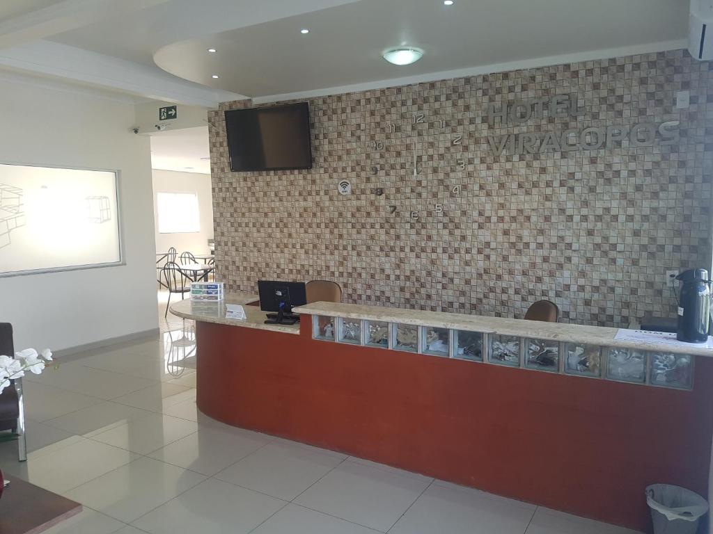 a restaurant with a reception counter and a tv on a wall at Hotel Viracopos de Indaiatuba in Indaiatuba