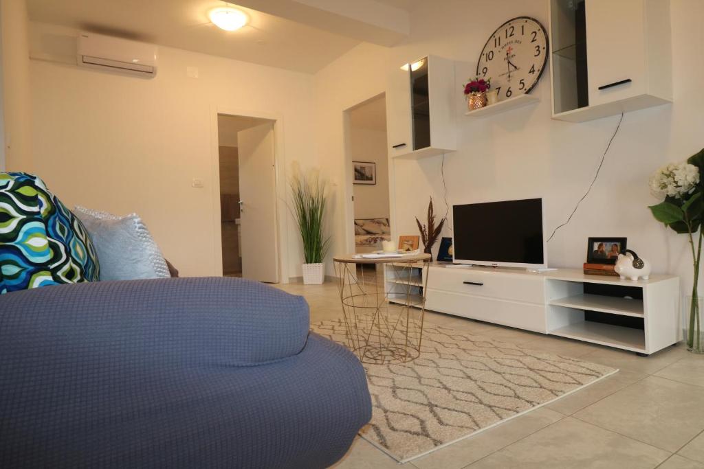 salon z kanapą i telewizorem w obiekcie Apartman La maison w mieście Zadar