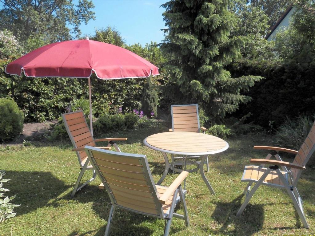 レリクにあるModern Apartment in Rerik with Gardenの赤い傘付き椅子3脚