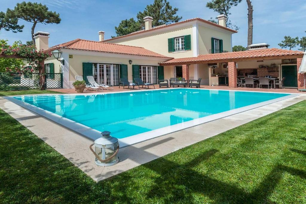 uma piscina em frente a uma casa em Villa Gerbera em Apostiça