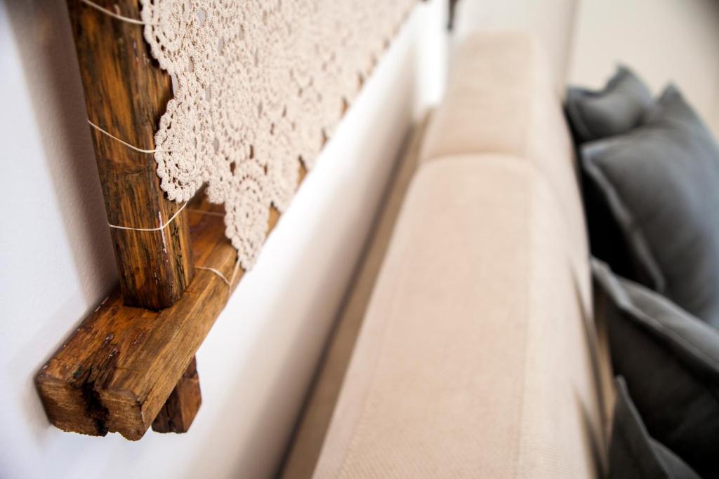 a corner of a couch with a wooden pole at Nenètte in Locorotondo