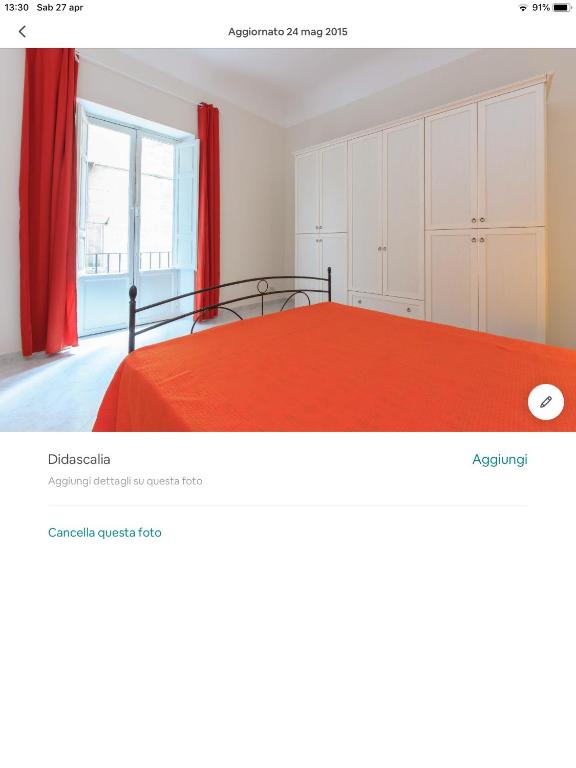 a bedroom with a red bed and a window at Spacious modern and cozy apartment in Trapani
