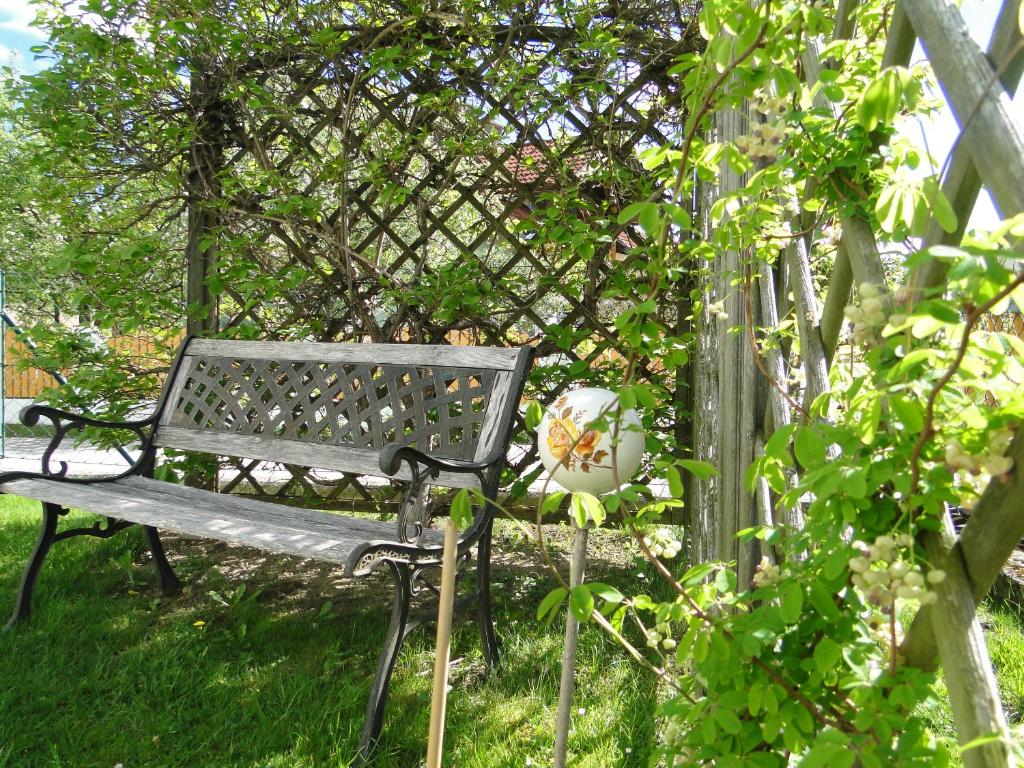 a bench sitting in the grass next to a fence at Apartment Ferienwohnung Kogler in Kraig