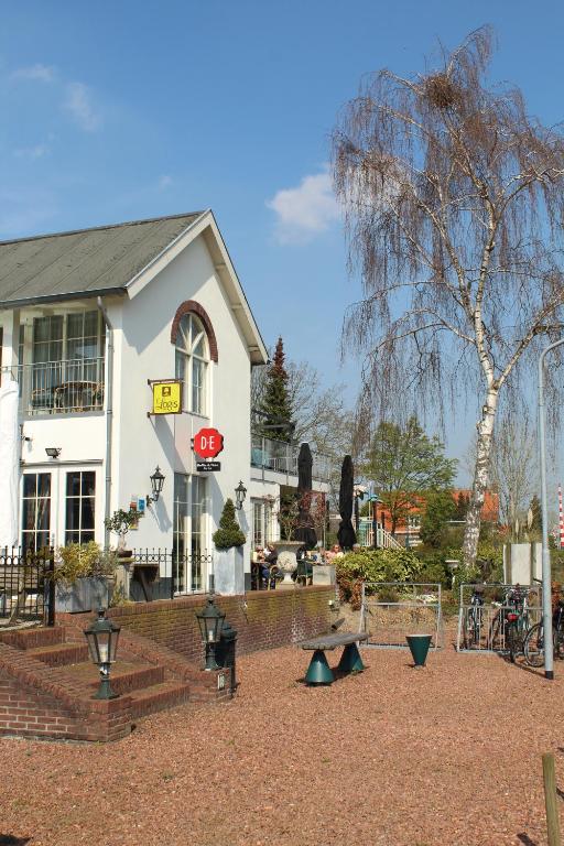 een wit huis met een stopbord en een speeltuin bij de Brabantse Biesbosch in Werkendam