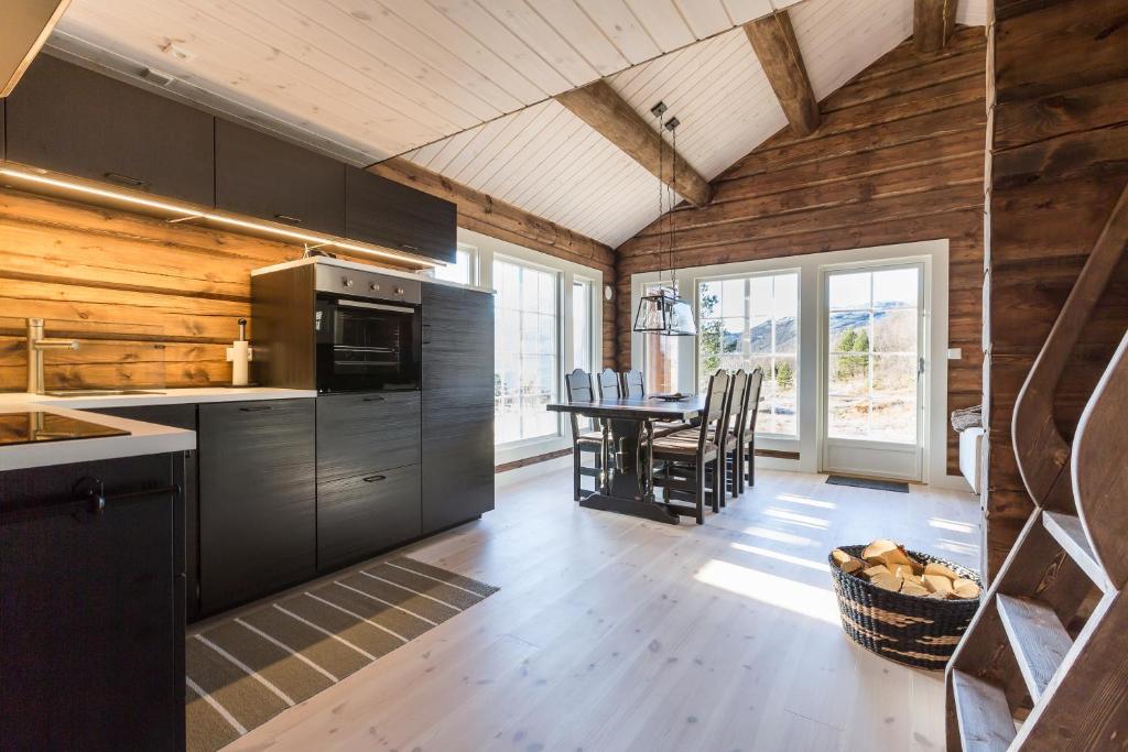 a kitchen with black appliances and a table with chairs at Mountain View in Stranda