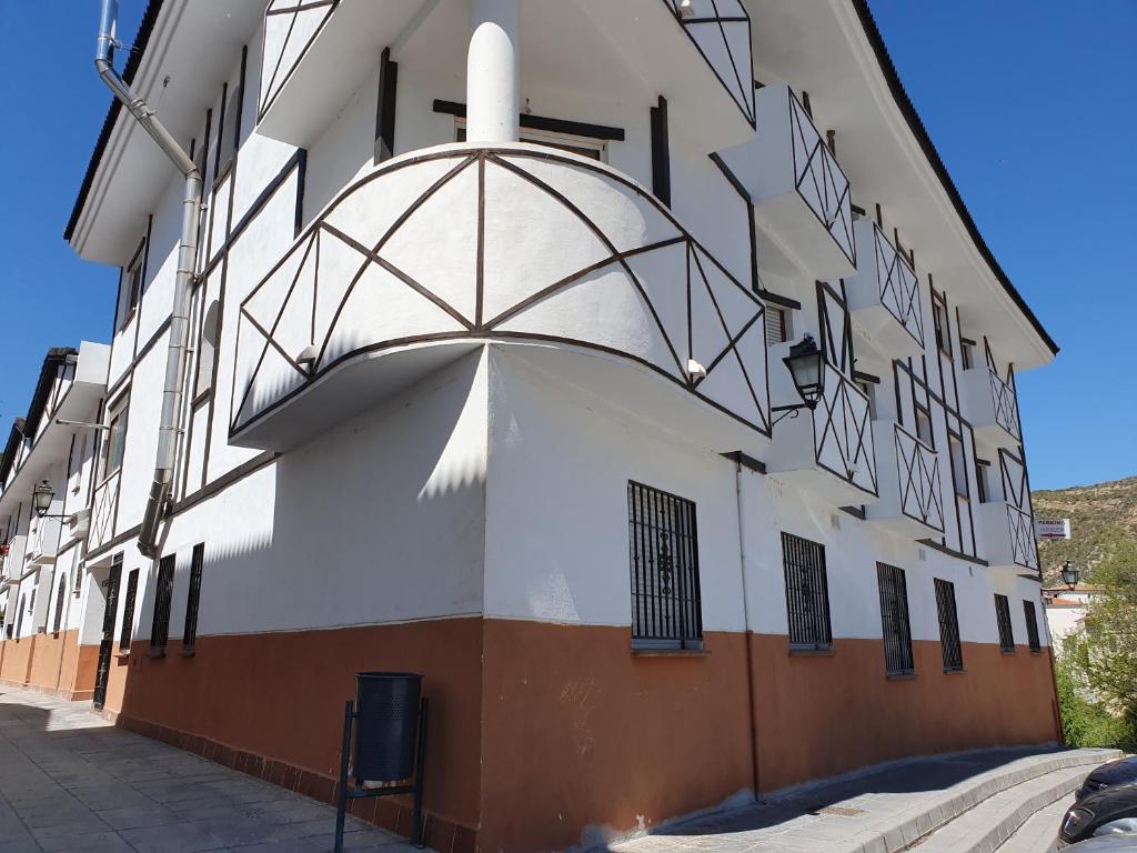 a white building with a black and white at Apartamentos Duquesa Sierra Nevada in Pinos Genil