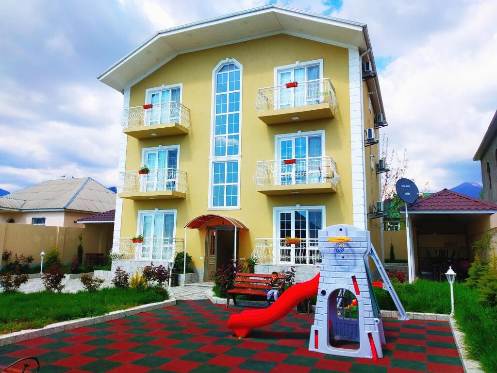 una casa con un parque infantil delante de ella en Gabala City Rooms en Gabala