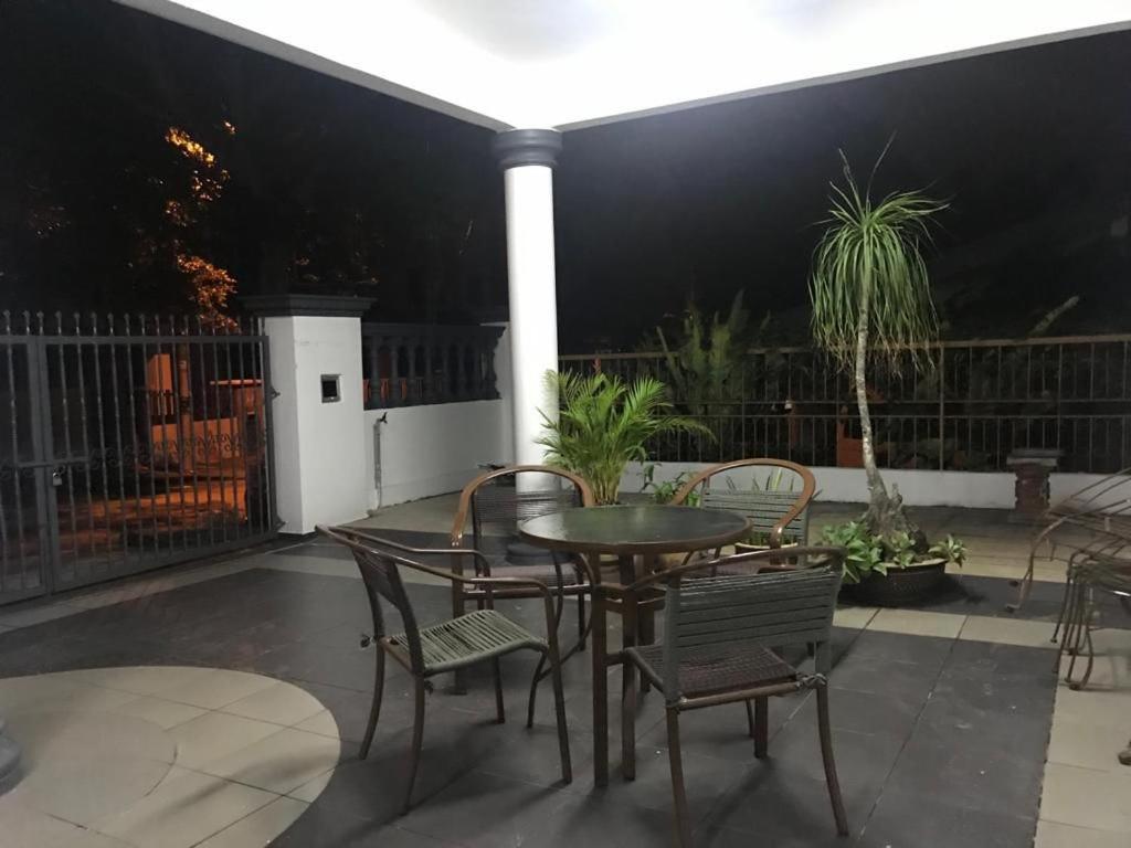 una mesa y sillas en un patio por la noche en JIAXIN HOMESTAY SEMENYIH BROGA SELANGOR, en Semenyih
