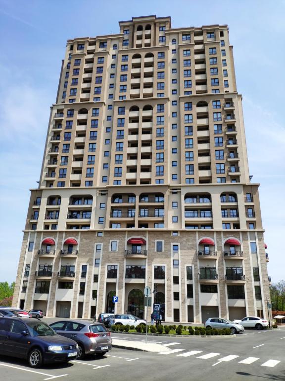 duży budynek z samochodami zaparkowanymi przed nim w obiekcie Delux Apartments Cote dAgur Burgas w Burgas