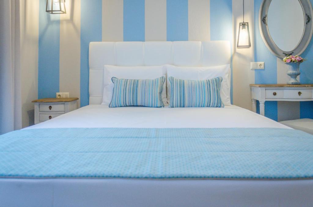 a bedroom with a large white bed with blue stripes at Palm Studios in Limenas