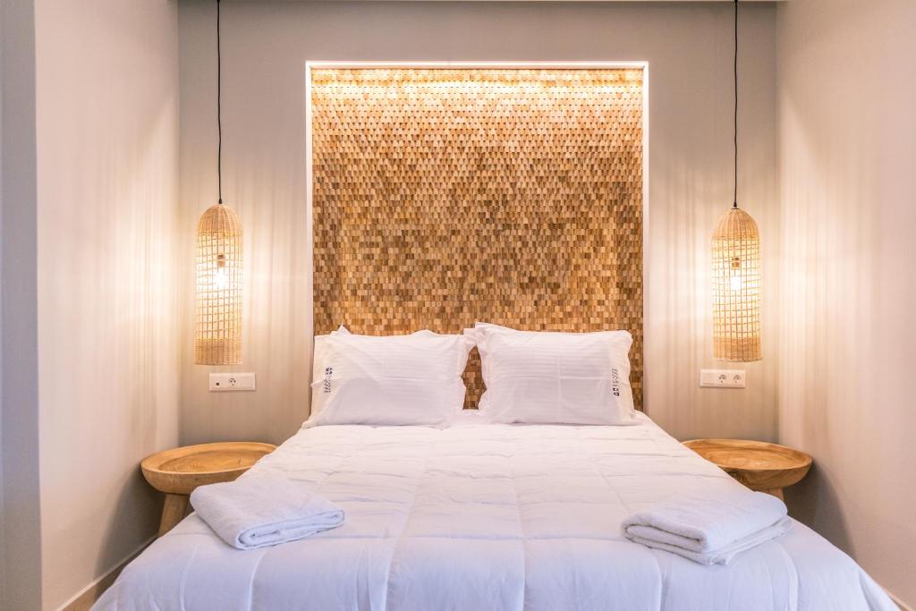 a bedroom with a large white bed with two pillows at Rarakos Houses Corfu in Corfu Town