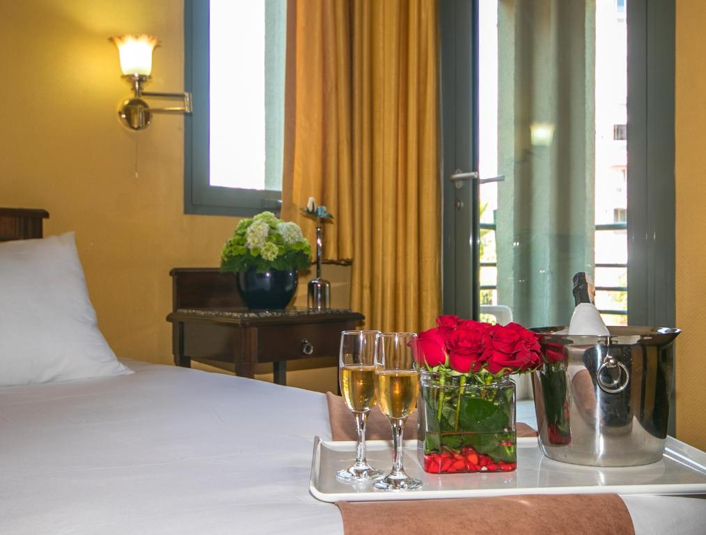a tray with two glasses of wine and flowers on a bed at Lara Park Hotel in Antalya