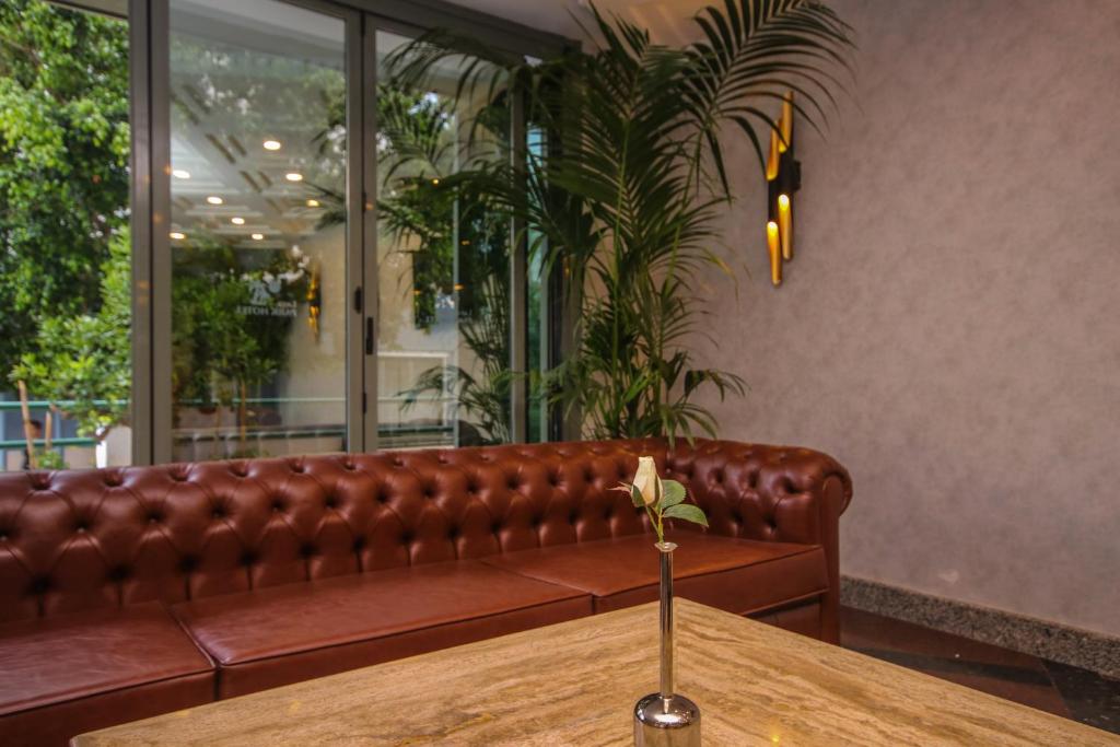 a brown leather couch in a restaurant with a wooden table at Lara Park Hotel in Antalya