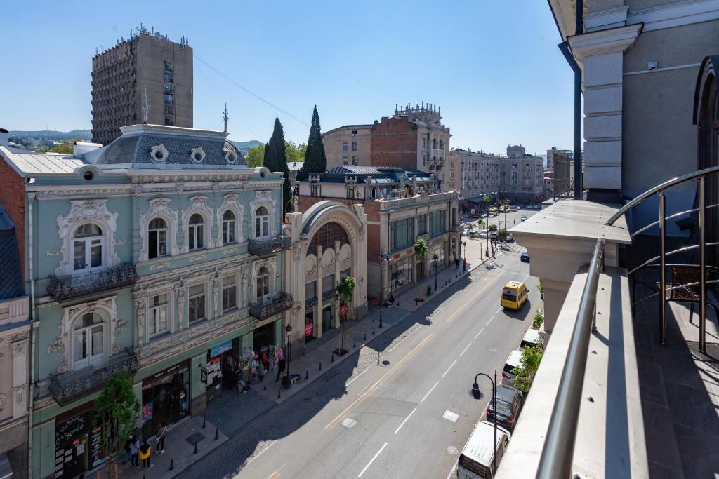 una calle de la ciudad con edificios y un taxi amarillo en Hotel Avenue 106 en Tiflis