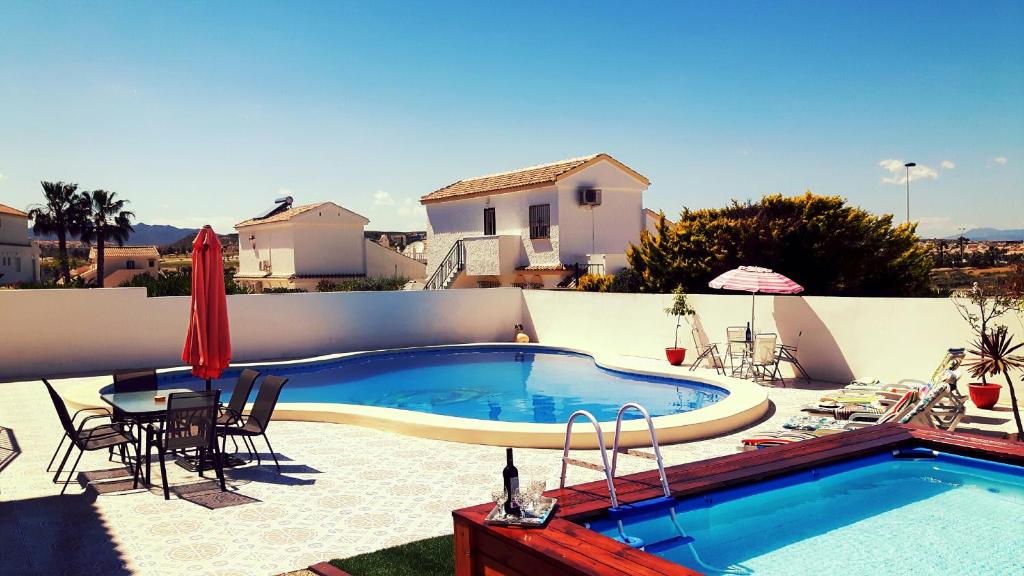 - une piscine sur une terrasse avec une table et des chaises dans l'établissement Camposol Casa Chantelle, à Camposol