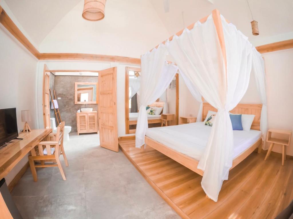 Dormitorio con cama con red en Bermuda Triangle Bungalows, en Siquijor