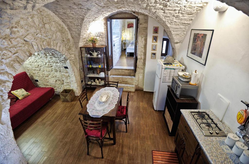 una cucina e un soggiorno con tavolo e divano di La Casina Petra a Ostuni