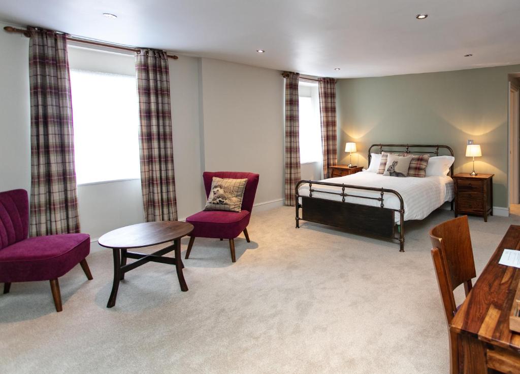a bedroom with a bed and a table and chairs at The Congresbury Arms in Congresbury