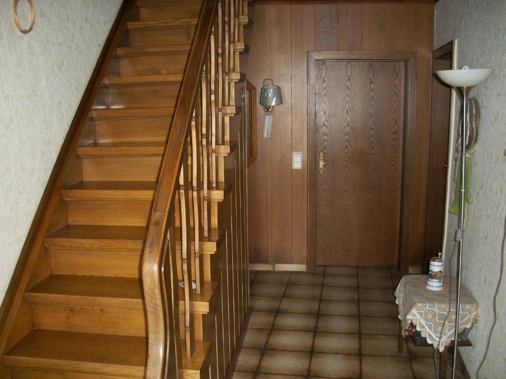 a hallway with wooden stairs and a door at Manfred Aepkers in Borgentreich