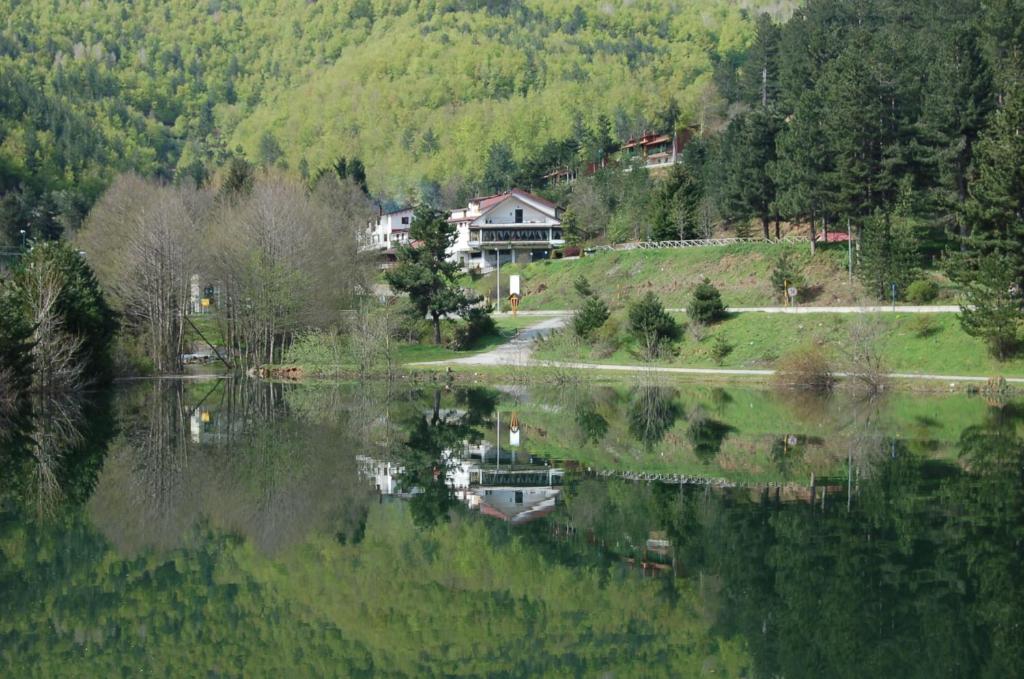 dom siedzący na szczycie wzgórza obok jeziora w obiekcie hotel lo sciatore w mieście Cotronei