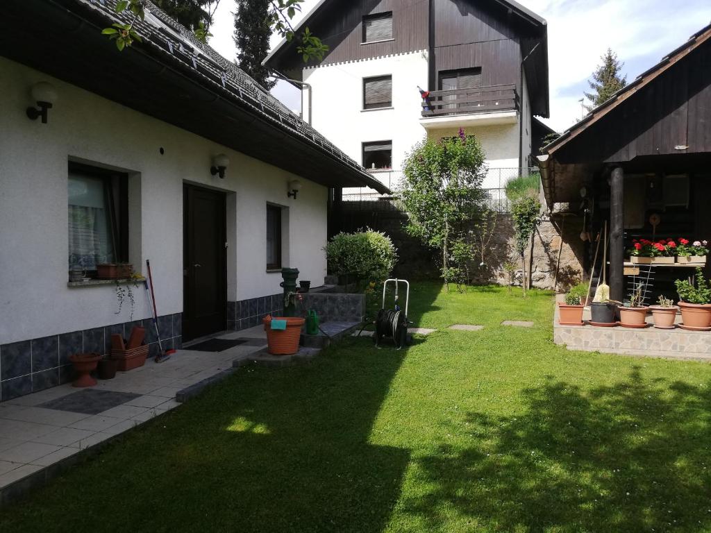 een achtertuin van een huis met een tuin met groen gras bij Apartment Sopar in Škofja Loka