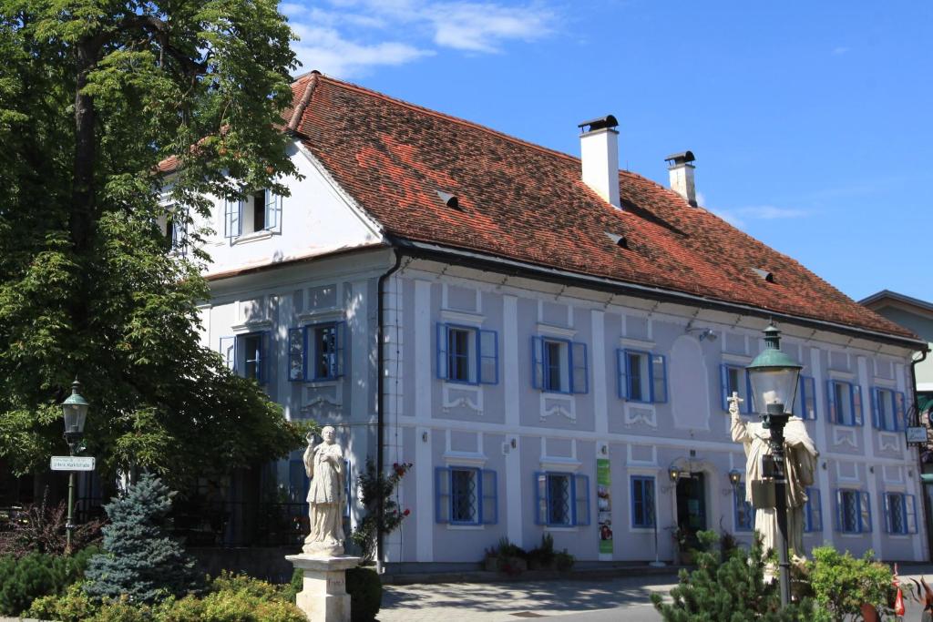 een groot wit gebouw met een rood dak bij Das Gästehaus in Sankt Veit am Vogau