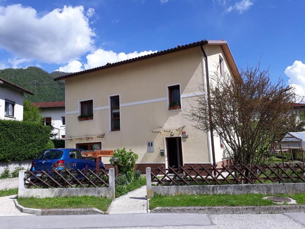 ein Haus mit einem blauen Auto, das davor geparkt ist in der Unterkunft Apartma Rutar in Tolmin