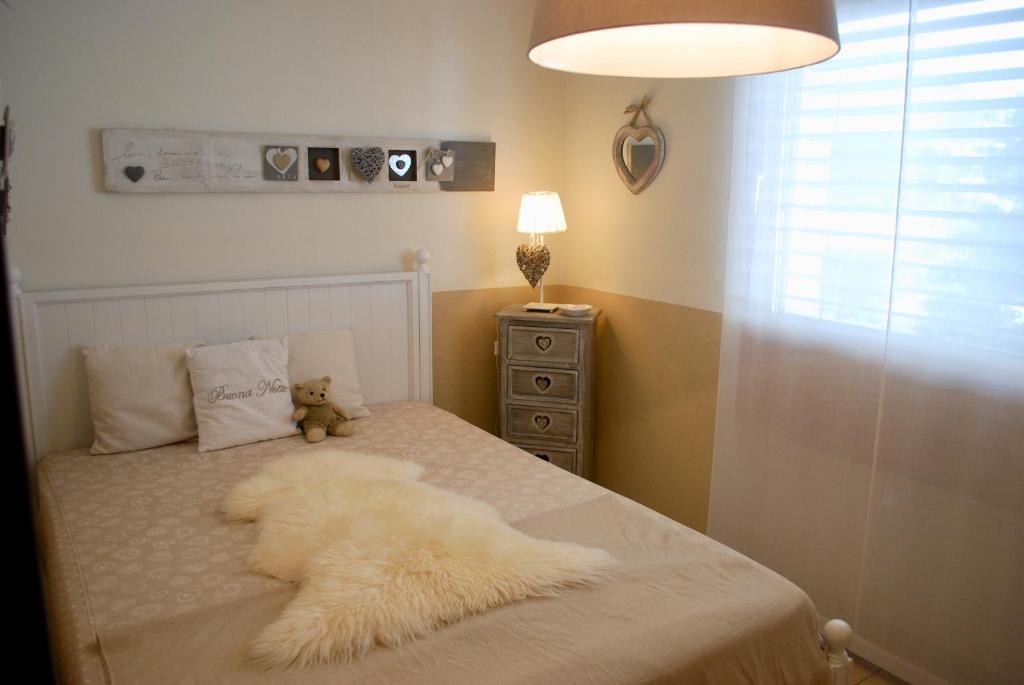 a white dog laying on a bed with a teddy bear at CENTRAL PENTHOUSE GREAT LAKE VIEW in St. Moritz