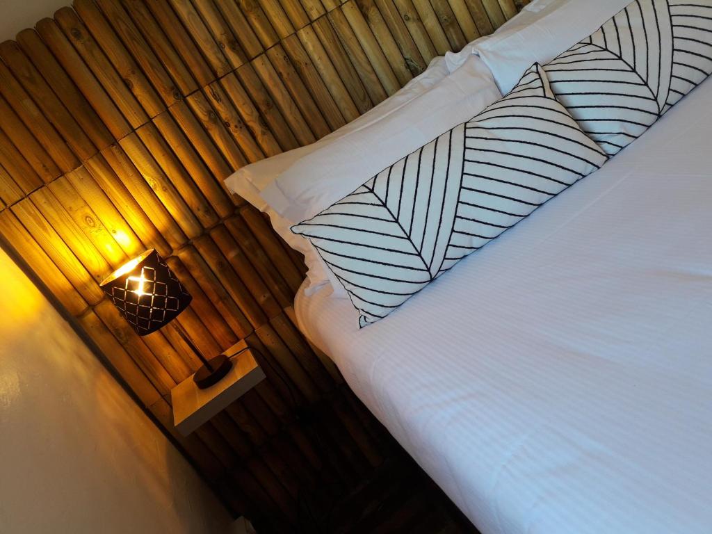 ル・バルカレスにあるHotel De La Merのベッドルーム1室(白いベッド1台、ランプ付)