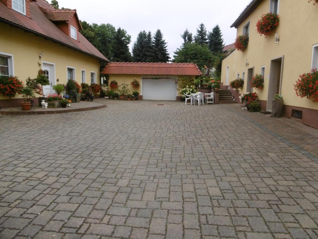 a cobblestone driveway in a courtyard between two buildings at Ferienwohnung Janke in Nossen
