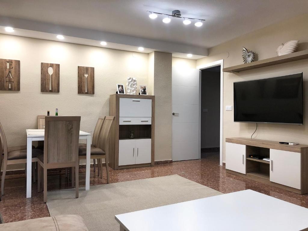 ein Wohnzimmer mit einem TV und einem Esszimmer in der Unterkunft Apartamento Cancun 7 Playa de Gandía in Playa de Gandia
