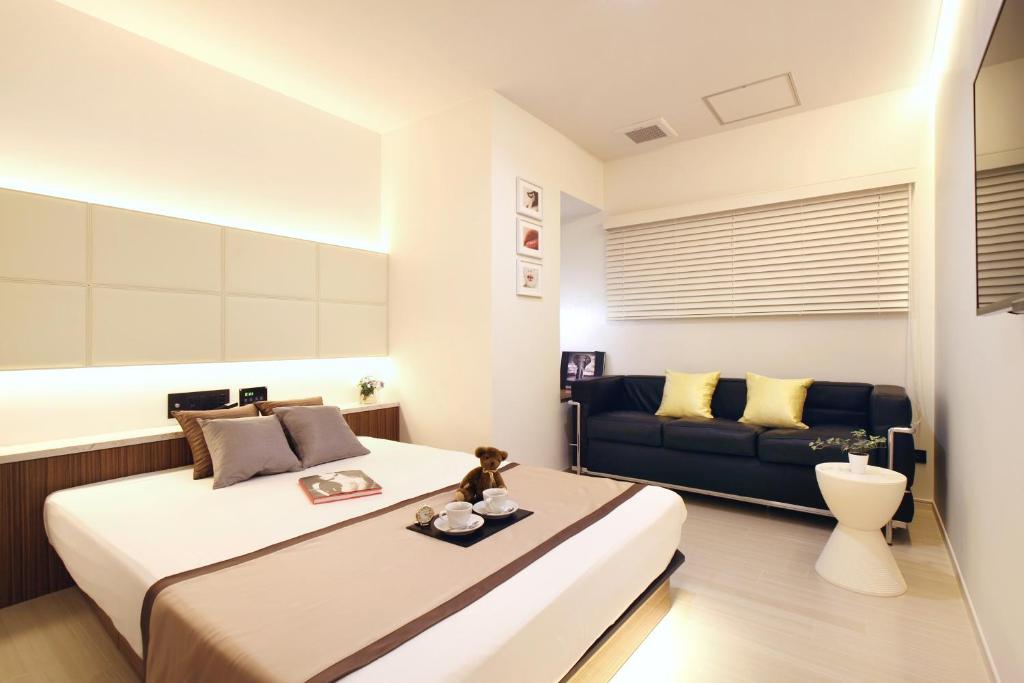 ein Schlafzimmer mit einem großen Bett und einem Sofa in der Unterkunft Hotel DUO kinsicho in Tokio