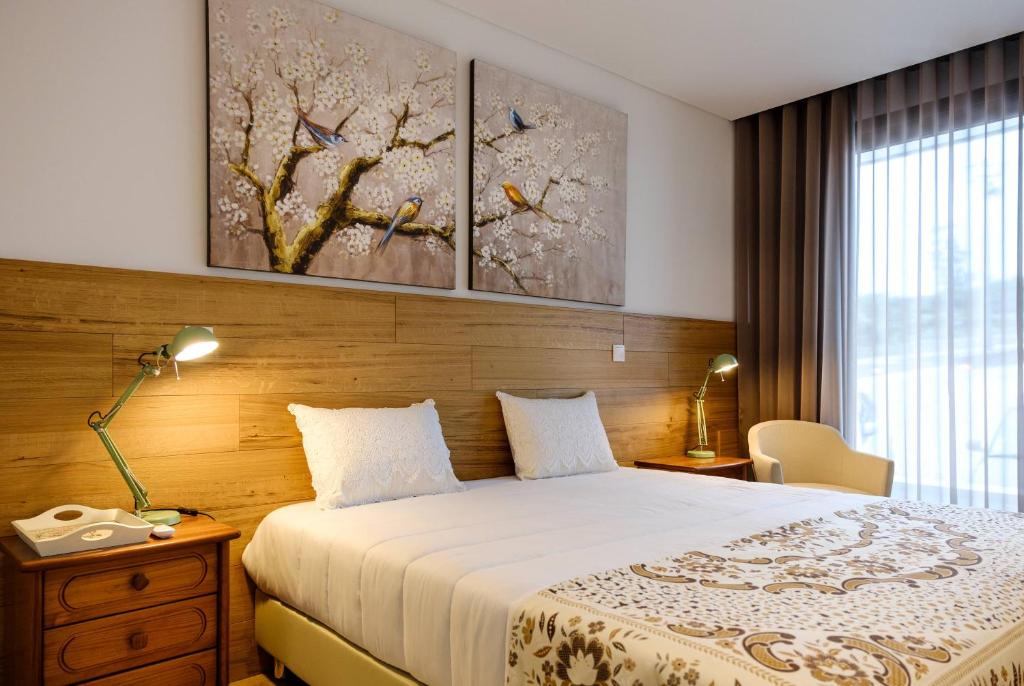 1 dormitorio con 1 cama con 2 cuadros en la pared en Rito Hall da Serra, en Leiria