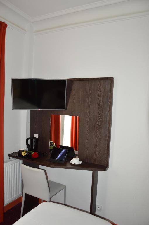 Cette chambre dispose d'un bureau et d'une télévision murale. dans l'établissement Parc Hotel, à Paris