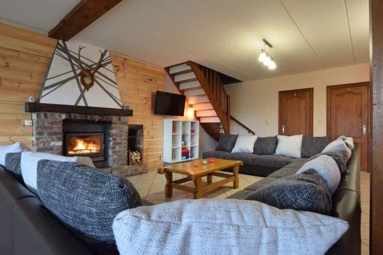 sala de estar con sofá y chimenea en L'orée du bois, en Roy