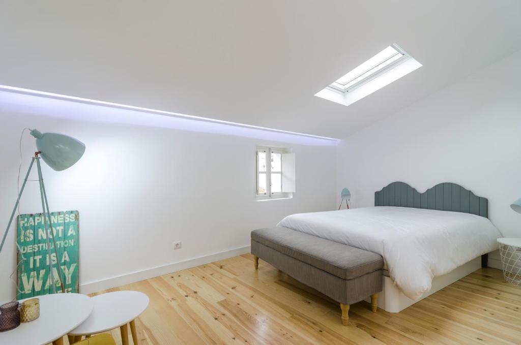 Dormitorio blanco con cama y mesa en Évora Art&Accommodation en Évora