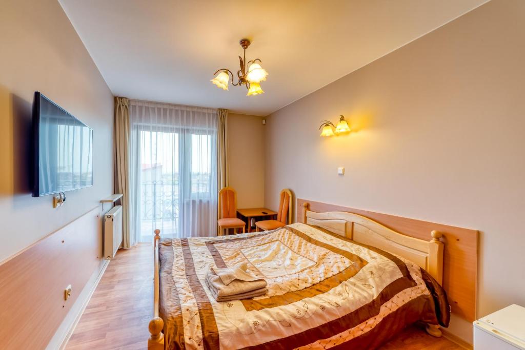 ein Schlafzimmer mit einem Bett und einem großen Fenster in der Unterkunft Willa Joker in Krynica Morska