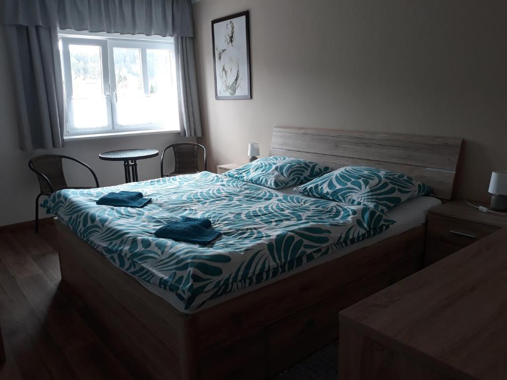 Schlafzimmer mit einem Bett mit einer blauen und weißen Bettdecke in der Unterkunft Ubytování Schindler in Velké Poříčí