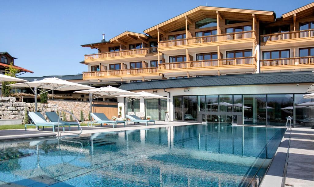 ein Hotel mit einem Pool vor einem Gebäude in der Unterkunft Laschenskyhof Hotel & Spa in Wals